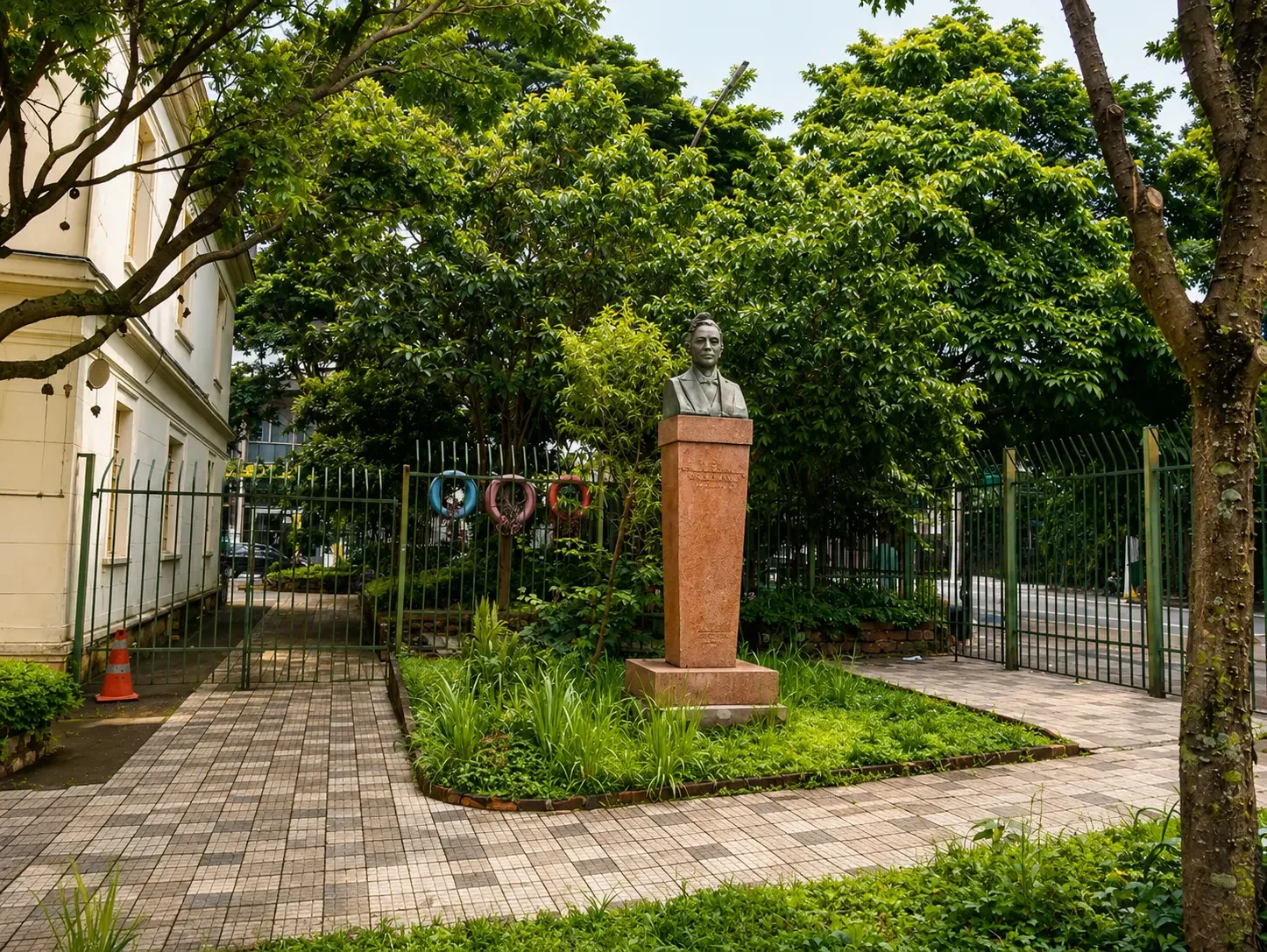 Praça arborizada com busto histórico e piso de mosaico em Santo Amaro